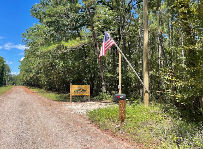 Forest Haven entrance beside the road, with the wooden sign, American flag, and markers for 520, 524, and 526