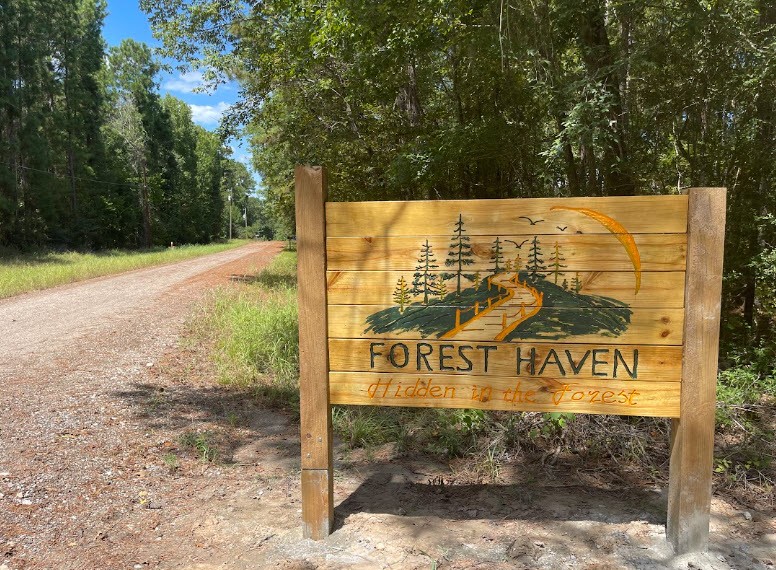 Forest Haven’s wooden entrance sign beside the drive